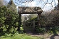 The picturesque old lychgate frames the tiny old Saxon church in spring sunshine at Duntisbourne Rouse