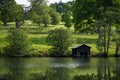Picturesque pastures with sheep and lake with old boat house, Scotland, UK Royalty Free Stock Photo