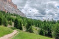 A picturesque path through an alpine meadow in the Italian Dolomites for hiking and cycling and alpine church Royalty Free Stock Photo