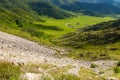 A picturesque place in the Altai Mountains with green trees and grass in the wild with a winding road at the foot under a blue sky Royalty Free Stock Photo