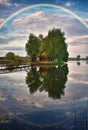 Picturesque rainbow over a wooden hut on a small island Royalty Free Stock Photo