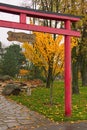 Picturesque rainy morning landscape. Red Torii Gate in Japanese garden. Text on sign: Kyoto park Royalty Free Stock Photo