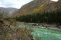 A picturesque river flowing calmly through a coniferous forest surrounded by mountains Royalty Free Stock Photo