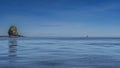 A picturesque rocky island with steep slopes is visible in the ocean.