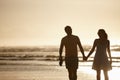 Picturesque romance. Silhouetted image of a couple holding hands in front of the sea.