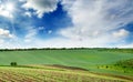 Picturesque rural landscape with a green spring field lit by the Royalty Free Stock Photo