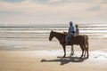 A picturesque scene of a California mounted patrol unit patrolling the sandy shores of a sunlit beach with the Pacific Ocean in