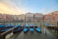 Picturesque scene of gondolas on canal in Venice, Italy, surrounded by urban buildings at sunset Royalty Free Stock Photo