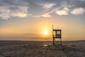 Picturesque scene of a lifeguard tower silhouetted against a stunning sunset over a sandy beach Royalty Free Stock Photo