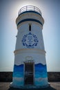 Picturesque scene of an Old lighthouse in Daman with a blue and white striped painted walls