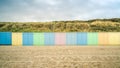 Picturesque scene of a tranquil sandy beach with a line of colorful beach huts Royalty Free Stock Photo