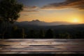 A picturesque scene wooden table with a sunset, sky, tree, mountains Royalty Free Stock Photo