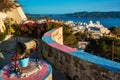 Picturesque scenic view of Greek town Plaka on Milos island over red geranium flowers Royalty Free Stock Photo