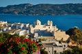 Picturesque scenic view of Greek town Plaka on Milos island over red geranium flowers Royalty Free Stock Photo