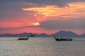 Seascape view with thai local long-tail boats floating in water at beautiful sunset on sea Royalty Free Stock Photo