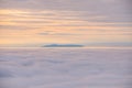 Picturesque shot of the beautiful mountain in the clouds at sunset