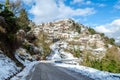 Picturesque Snowy Village of Upper Vlasia in Greece. Traditional Houses in Amphitheatrical Architecture on a Sunny Day of Winter. Royalty Free Stock Photo