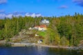 Picturesque spring coastal landscape of Stockholm archipelago with luxury waterfront mansion surrounded by bare trees and the