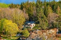 Picturesque spring coastal landscape of Stockholm archipelago with luxury waterfront mansion surrounded by bare trees and the