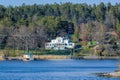 Picturesque spring coastal landscape of Stockholm archipelago with luxury waterfront mansion surrounded by bare trees and the