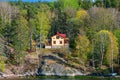 Picturesque spring coastal landscape of Stockholm archipelago with luxury waterfront mansion surrounded by bare trees and the