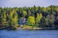 Picturesque spring coastal landscape of Stockholm archipelago with luxury waterfront mansion surrounded by bare trees and the