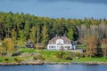 Picturesque spring coastal landscape of Stockholm archipelago with luxury waterfront mansion surrounded by bare trees and the