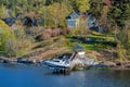 Picturesque spring coastal landscape of Stockholm archipelago with waterfront mansion and small motor boat hoisted above water on