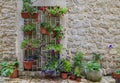 Picturesque stone wall in the streets of a preserved medieval Old town with colorful potted flowers in Budva, Montenegro