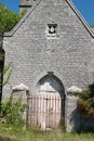An attractive Purbeck stone house with a arched wooden door and iron gates