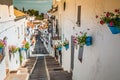 Picturesque street of Mijas with flower pots in facades. Andalusian white village. Costa del Sol. Southern Spain Royalty Free Stock Photo