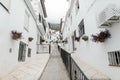 Picturesque street of Mijas with flower pots in facades. Andalusian white village. Costa del Sol. Southern Spain. Royalty Free Stock Photo