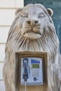 Picturesque street telephone cabinet inside a lion head sculputure. Vertical Royalty Free Stock Photo