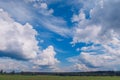 Picturesque summer landcsape with white fluffy summer clouds on blue marvelous sky view background. Green meadow stock photo Royalty Free Stock Photo