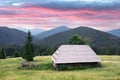 Picturesque summer meadow with wooden house