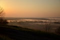 Picturesque sunrise over a foggy meadow on a summer morning. Country road, horizontal photo.