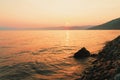 Picturesque sunset in golden orange colors on a rocky beach, late summer evening Royalty Free Stock Photo