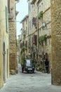 Picturesque three-wheeler in narrow street of historical town, Pienza, Siena, Italy Royalty Free Stock Photo