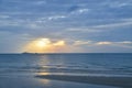 A picturesque tropical gold coloured crepuscular rays cloudy coastal sunrise seascape in a blue/grey sky. Thailand