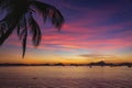 Picturesque tropical sunset. Dramatic evening sky above island. Palm tree and isles silhouettes. Exotic seascape in twilight. Royalty Free Stock Photo
