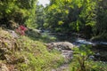 Picturesque valley in mountains and calm river. Boulders in the riverbed and rocks along the valley.