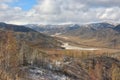 A picturesque valley in the mountains sprinkled with the first snow under a cloudy autumn sky Royalty Free Stock Photo