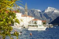 Picturesque view of ancient city of Perast, Montenegro. Boy in old medieval little town with red roofs and majestic mountains on