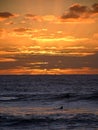 Picturesque view of beautiful yellow-orange sunset sky with abstract clouds over undulating ocean Royalty Free Stock Photo