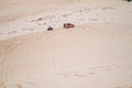 Picturesque view of big car driving on sandy dunes and tire tracks on sand Royalty Free Stock Photo