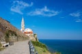 Scenic view of coastline of Adriatic sea with alley along Piran old city walls and cathedral on background, Slovenia Royalty Free Stock Photo
