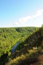 A picturesque view of the endless taiga from the top of the mountain and the calm river flowing below