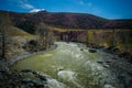 Picturesque view of the fast river among blooming mountains, spring landscape. Colorful hills under blue sky on sunny day Royalty Free Stock Photo