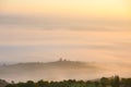 Picturesque view of foggy rolling fields of Tuscany in the light of the rising sun, Italy