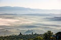 Picturesque view of foggy rolling fields of Tuscany in the light of the rising sun, Italy